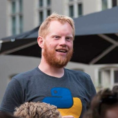 A torso photo of me talking, while wearing a Python t-shirt